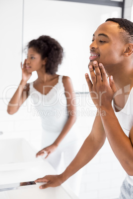 Couple checking their skin in bathroom