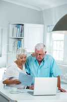 Senior couple reading document at home