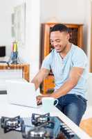 Young man using laptop in kitchen