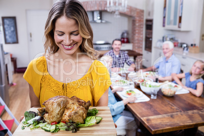 Happy woman holding a tray of roasted turkey