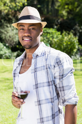 Young man holding wine glass the in garden