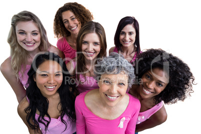 Smiling women in pink outfits posing for breast cancer awareness