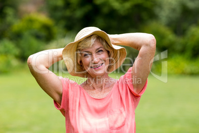Senior woman wearing hat standing in yard