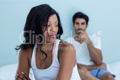 Upset couple ignoring each other after fight on bed