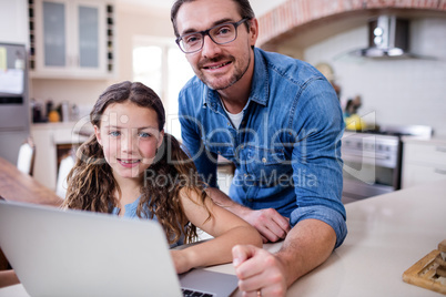 Portrait of father and daughter using laptop in kitchen Portrait of father and daughter using laptop in kitchen