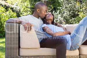 Young man kissing woman on her cheeks