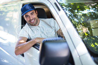 Cheerful delivery person sitting in van