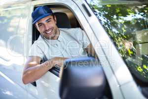 Cheerful delivery person sitting in van