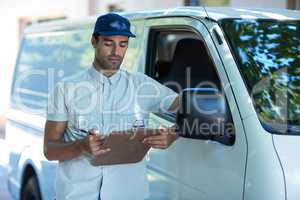 Delivery person looking at clipboard
