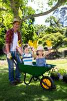 Father carrying his son and daughter in a wheelbarrow