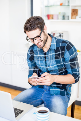 Cute nerd texting on smartphone