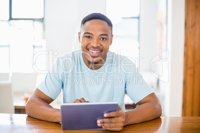 Happy young man using digital tablet