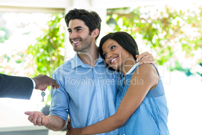 Real estate agent giving house keys to the couple