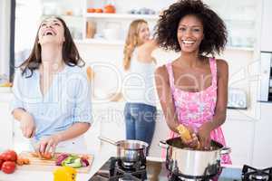 Friends preparing a meal in kitchen