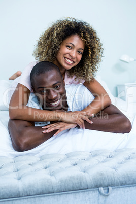 Young couple cuddling on bed