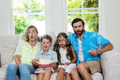 Portrait of surprised family laughing while watching tv