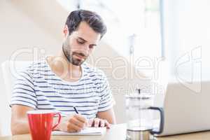 Man writing note on notepad