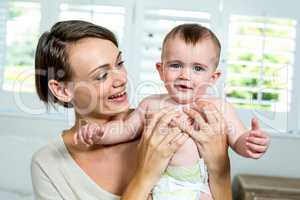 Happy mother carrying son at home