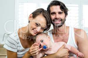 Happy parents with baby boy in bedroom