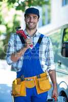 Portrait of smiling carpenter holding pipe wrench
