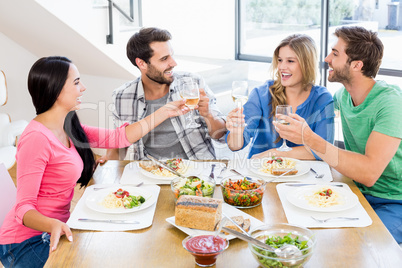 Friends toasting wine glasses while having a meal