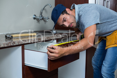 Man measuring drawer size