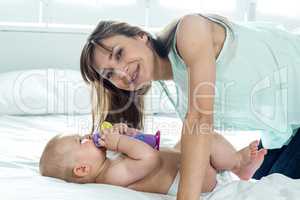 Woman with playful son on bed at home