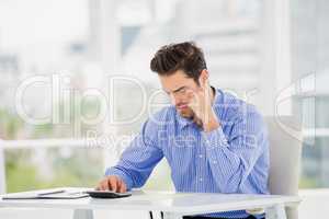 Businessman calculating accounts on a calculator