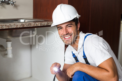 Portrait of smiling man holding illuminated torch