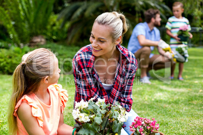 Smiling mother looking at daughter in yard