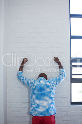 Upset man leaning against wall