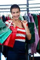 Happy woman holding shopping bags in clothes shop