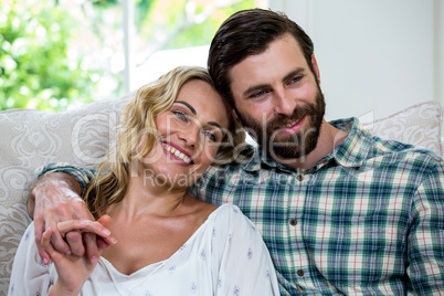 Thoughtful couple sitting on sofa