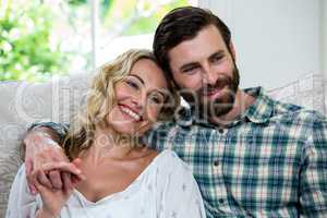 Thoughtful couple sitting on sofa