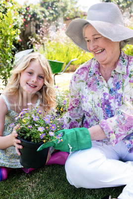 Grandmother and granddaughter holding a flower pot