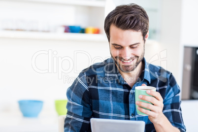 Man using digital tablet while having coffee