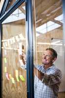 Man looking at sticky notes on window