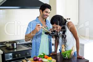 Young couple cooking food together in kitchen