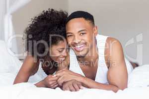 Young couple lying on bed and embracing each other