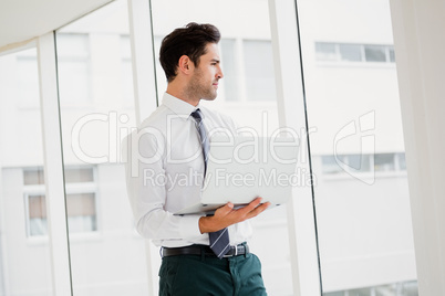 Businessman using laptop and taking notes