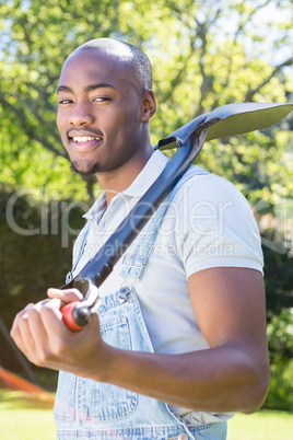 Young man posing with a shovel