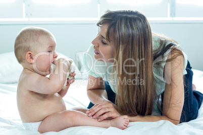 Woman playing with baby boy on bed