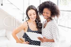 Businesswomen looking at clipboard and interacting