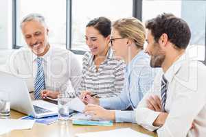 Business colleagues discussing office work on laptop