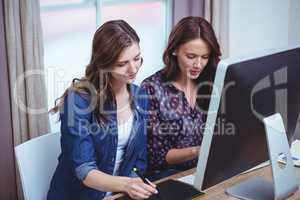 Two beautiful woman using computer and pen tablet