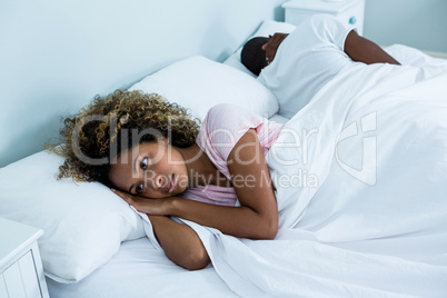 Young couple sleeping back to back and ignoring each other