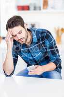 Worried man text messaging on mobile phone