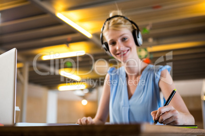 Graphic designer listening to headphones while using graphic tab