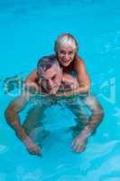 Happy senior couple enjoying in swimming pool
