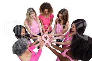 Women in pink outfits standing in a circle for breast cancer awa